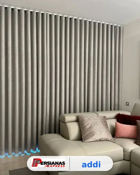 Cortina de tela gris con caída en ondas en sala