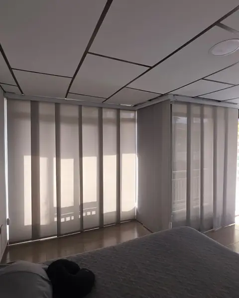 Panel japonés gris instalado en habitación con ventanales